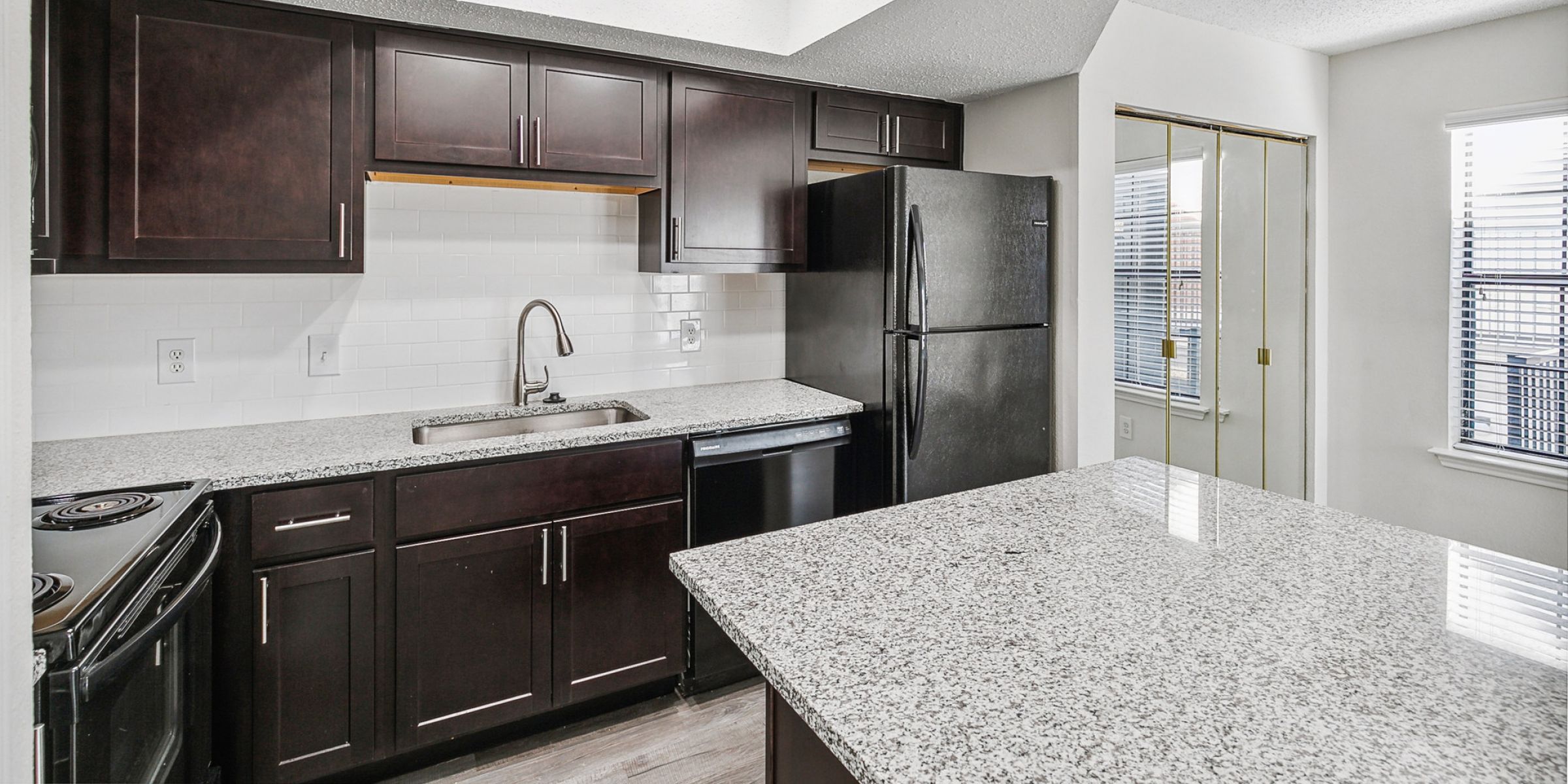 Luxury apartment living room with large windows, wood style floors and contemporary furniture at The Civic at Frisco Square